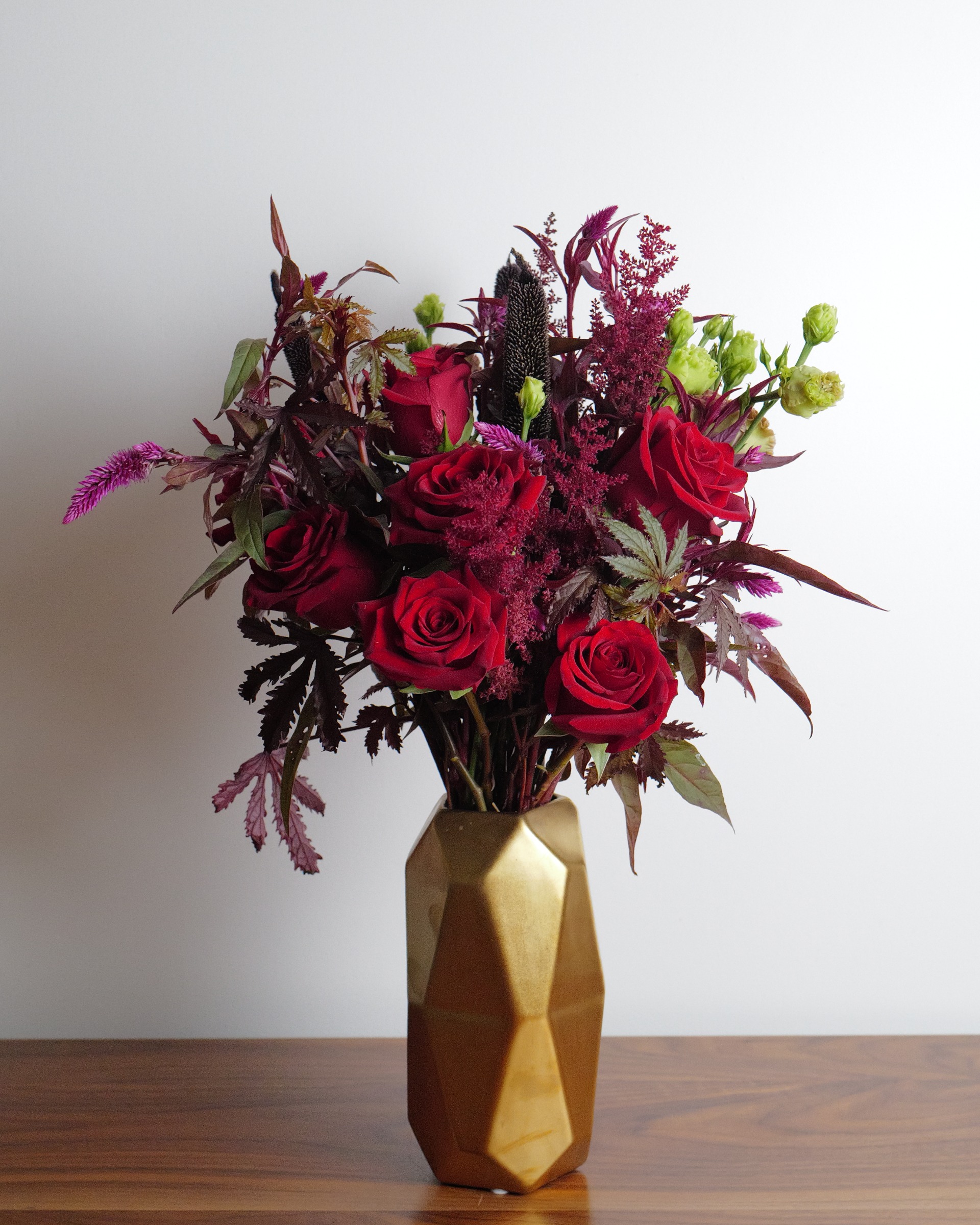 A  bouquet filled with goth flowers in the deepest burgundy, wine, and purple colors.